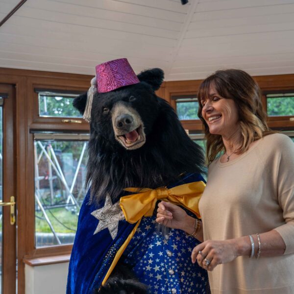 Magician bear next to Carol Smillie on set of Conservandsave shoot