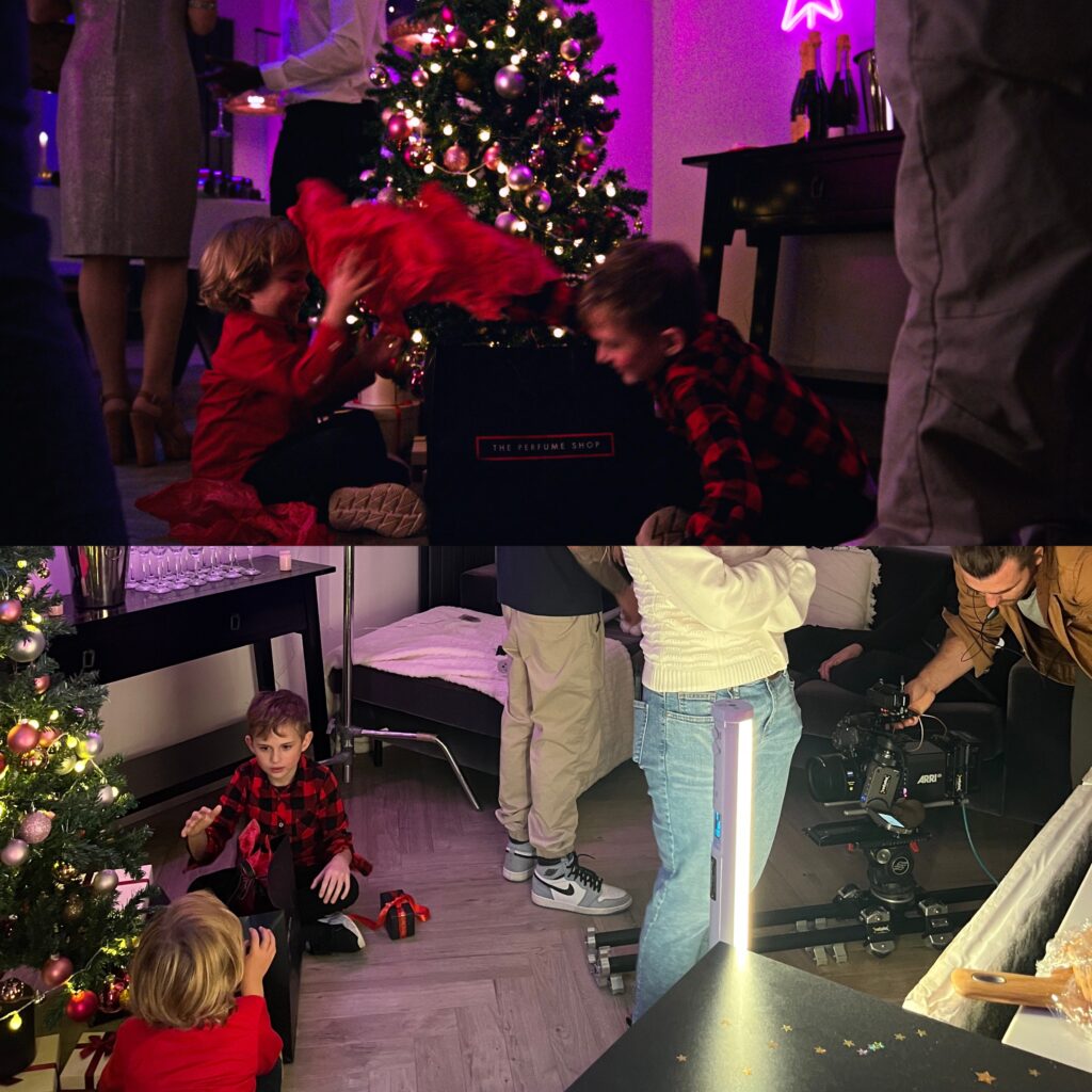 Final shot vs the set up of filming children playing with the perfume shop bag in front of christmas tree