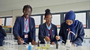 3 King Edward VI Foundation students in a science lab