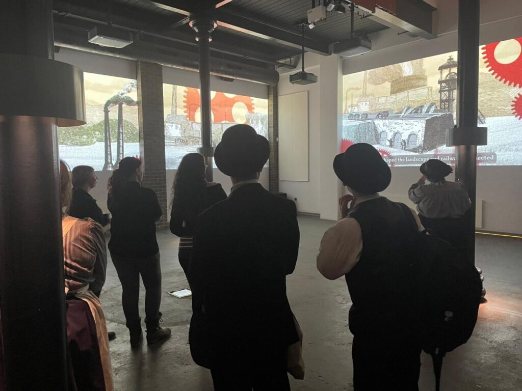 Visitors at Ironbridge Gorge Museum watching the audio-visual production Spark Media created