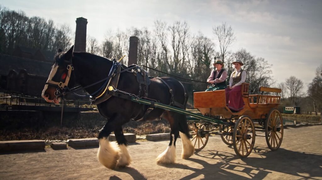 Two women dressed in Victorian clothes in a carriage pulled by a horse at Ironbridge