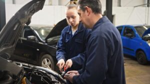 student in motor vehicle workshop with teacher