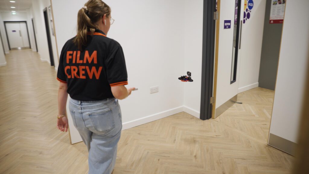 Producer with Film Crew top following FPV drone inside Mondelēz International new research facility