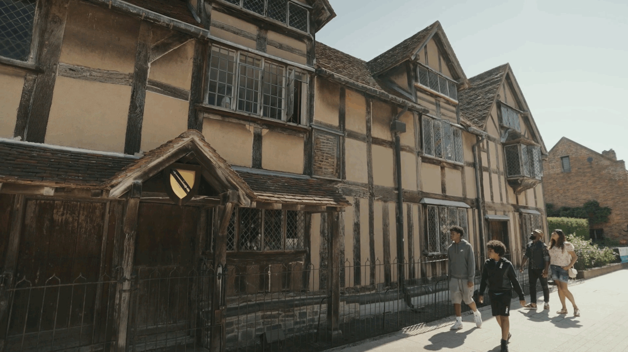 4-person family, mum, dad and 2 boys walking in front of Shakespeare's Birthplace house in stratford-upon-Avon