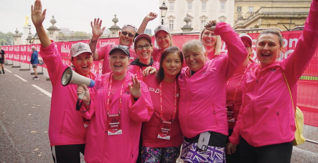Volunteers at a London Marathon Event wearing pink cheering