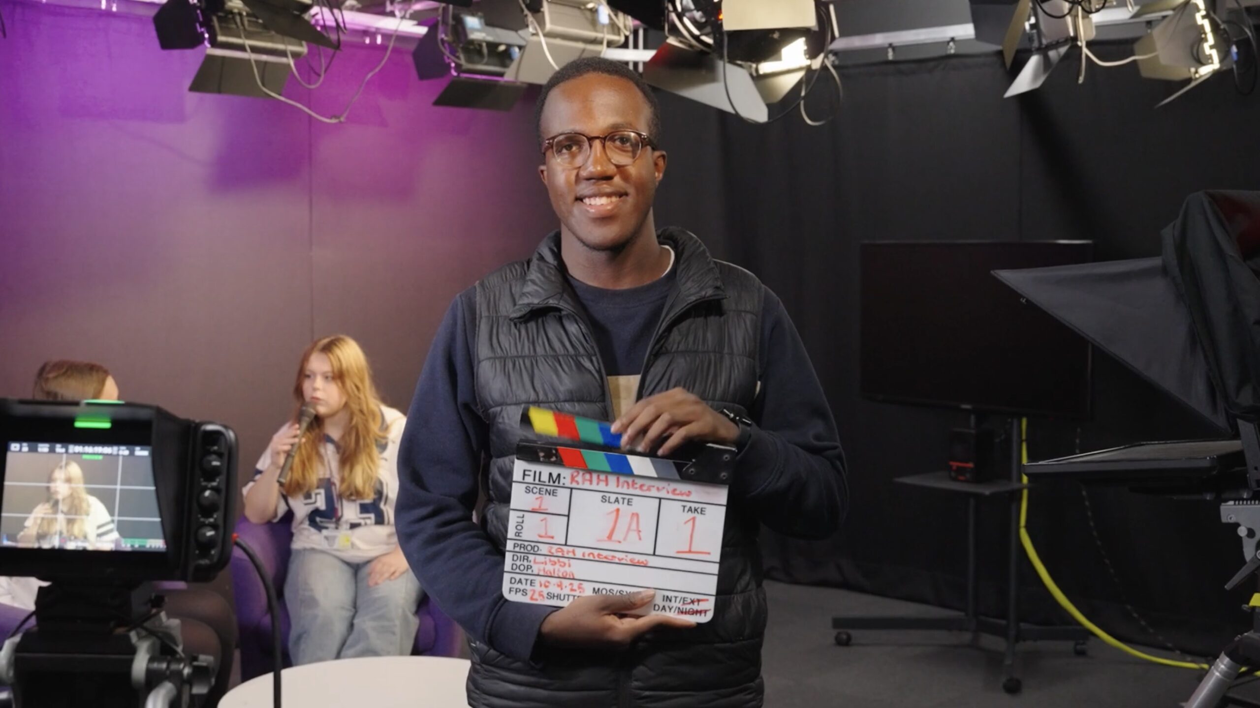College Student Hero shot holding clapperboard in media class