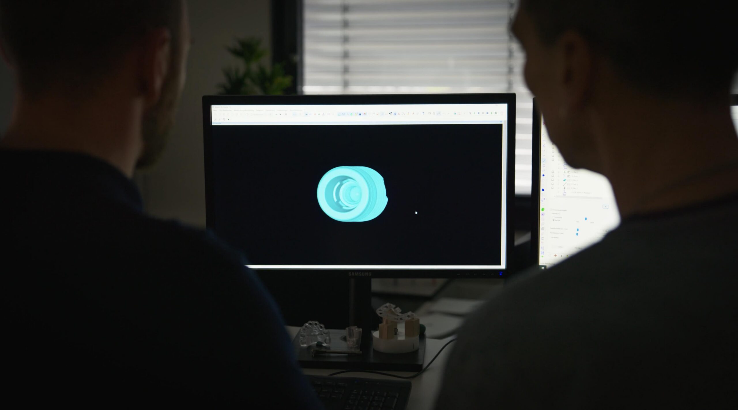 Two people looking at model of Camlog product on a computer screen.