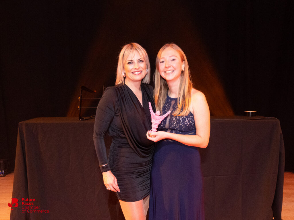 Becca being presented a pink trophy at the Greater BYPY Awards.